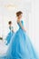 Beautiful bride in gorgeous blue dress Cinderella style near mirror