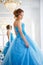 Beautiful bride in gorgeous blue dress Cinderella style near mirror