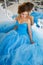 Beautiful bride in gorgeous blue dress Cinderella style near mirror
