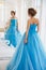 Beautiful bride in gorgeous blue dress Cinderella style near mirror