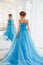 Beautiful bride in gorgeous blue dress Cinderella style near mirror