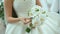 Beautiful bride is holding white wedding bouquet. Bridal accessories. Details for marriage