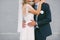 Beautiful bride hugs groom on a gray background, wedding, marriage, relationship, lifestyle