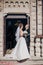 Beautiful bride kissing with stylish groom, standing at church after wedding matrimony. Gorgeous wedding couple after wedding holy
