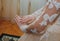 Beautiful bride in the long sleeved dress is looking at her manicure. Nude nails wedding design.Bridal morning details