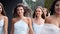 Beautiful bride, pretty bridemaids in pale blue dresses walk cheering waving hands. Woman with long airy bridal veil in