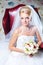 Beautiful bride sitting in red armchair