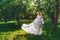 Beautiful bride in summer green park. Girl in vintage dress.