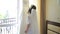 Beautiful bride touches wedding dress and removes it