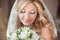 Beautiful bride with wedding bouquet of flowers. Makeup. Blond c