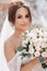 Beautiful bride in a wedding dress with a bouquet on the top of the salt mountains. A stunning young bride with curly hair .