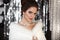 Beautiful bride with wediing set jewelry. Gorgeous brunette girl in white fur coat over Chrismas bokeh background. Bridal winter