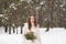 Beautiful bride in a white dress with a bouquet in a snow-covered winter forest. Portrait of the bride in nature