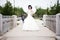 Beautiful bride in white dress on bridge witch umbrella