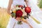 A beautiful bride in a white dress holds a bouquet