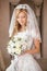 Beautiful bride woman with bouquet of flowers, wedding makeup an