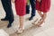 Beautiful bridesmaids and groomsmen standing in church during wedding ceremony, tired elegant bridesmaid standing barefoot near