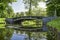 Beautiful bridge over the cross canal in the garden. Water landscape