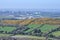 Beautiful bright aerial-like view of yellow flowering gorse green fields, cemetery and Dublin city seen from Ballycorus Lead Mines