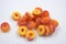 Beautiful and bright colored sweets in the form of orange and red doughnuts in sugar powder, arranged on a white matte background.