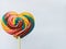 Beautiful bright colorful lollipops like a rainbow shaped like a heart isolated on a white background