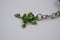 A beautiful, bright keychain decorated with small green frogs, toads with small green stones.