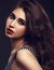 Beautiful bright makeup woman with long brown curly volume hair style, red lipstick, and black smokey eyes and wide bushy brow