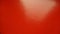 Beautiful bright red background. Closeup sheet of shiny reflecting incident light paper. Pure fun color. Intense shade of red,