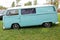 Beautiful bright turquoise classic Volkswagen transporter van on a field