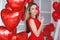 Beautiful bright woman with red balloons on Valentine`s day