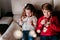 beautiful brother and sister at home playing with garland of lights. Christmas concept