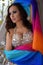 Beautiful brunette, belly dancer with rainbow shawl in the arabic harem interior