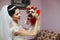 Beautiful brunette bride in white dress holding cute little puppie with a ribbon