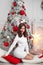 Beautiful brunette in Christmas interior. Elegant winter woman in white dress present gift box with red ribbon bow, pretty lady in