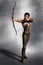 Beautiful brunette female archer holding bow and arrow in shooting pose