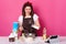 Beautiful brunette female pours milk into plate. Chef kneads dough, preparing for Easter holiday, making hot cross buns. Pink