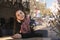 Beautiful brunette girl behind glass, portrait, coffee shop window, concept of female emotions