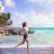 Beautiful brunette girl running in Caribbean beach