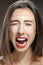 Beautiful brunette girl studio portrait. Screaming and surprised expression