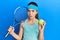 Beautiful brunette little girl playing tennis holding racket and ball clueless and confused expression