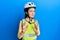 Beautiful brunette little girl wearing bike helmet and reflective vest disgusted expression, displeased and fearful doing disgust