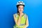 Beautiful brunette little girl wearing bike helmet and reflective vest looking confident at the camera smiling with crossed arms