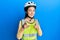 Beautiful brunette little girl wearing bike helmet and reflective vest pointing fingers to camera with happy and funny face