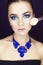 Beautiful brunette model woman in blue necklace and with evening