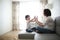 Beautiful brunette mom and son hugging sofa