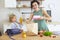 Beautiful brunette mother and her daughter packing healthy lunch and preparing school bag