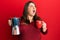 Beautiful brunette plus size woman drinking italian coffee angry and mad screaming frustrated and furious, shouting with anger