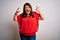 Beautiful brunette plus size woman wearing casual red t-shirt over isolated white background shouting with crazy expression doing