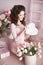 Beautiful brunette teen girl portrait open present, romantic surprise. pretty woman in pink dress over bouquet of flowers and gif
