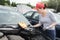 Beautiful brunette trying to repair broken car